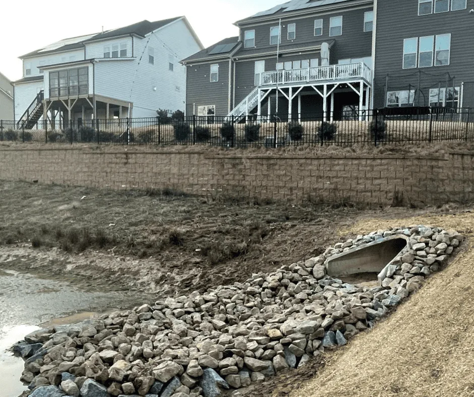Stone rip-rap dissipater along a stabilized pond bank
