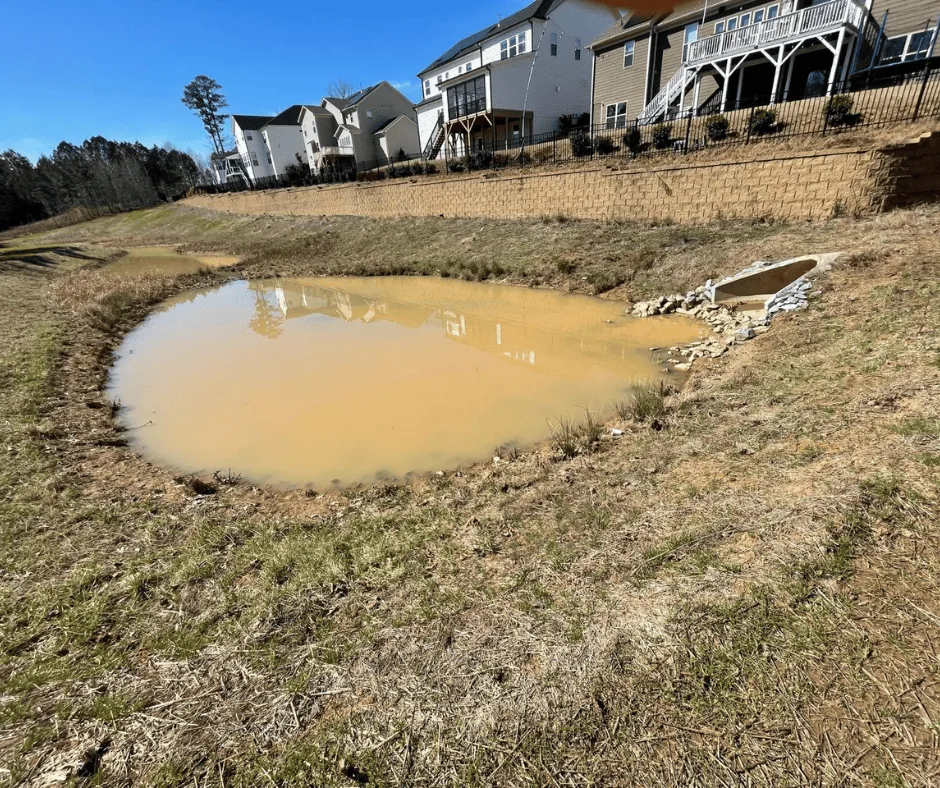 Stone rip-rap dissipater pad at a pond outlet, aerial view