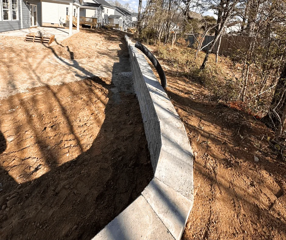 Finished retaining wall stabilizing the slope behind a home