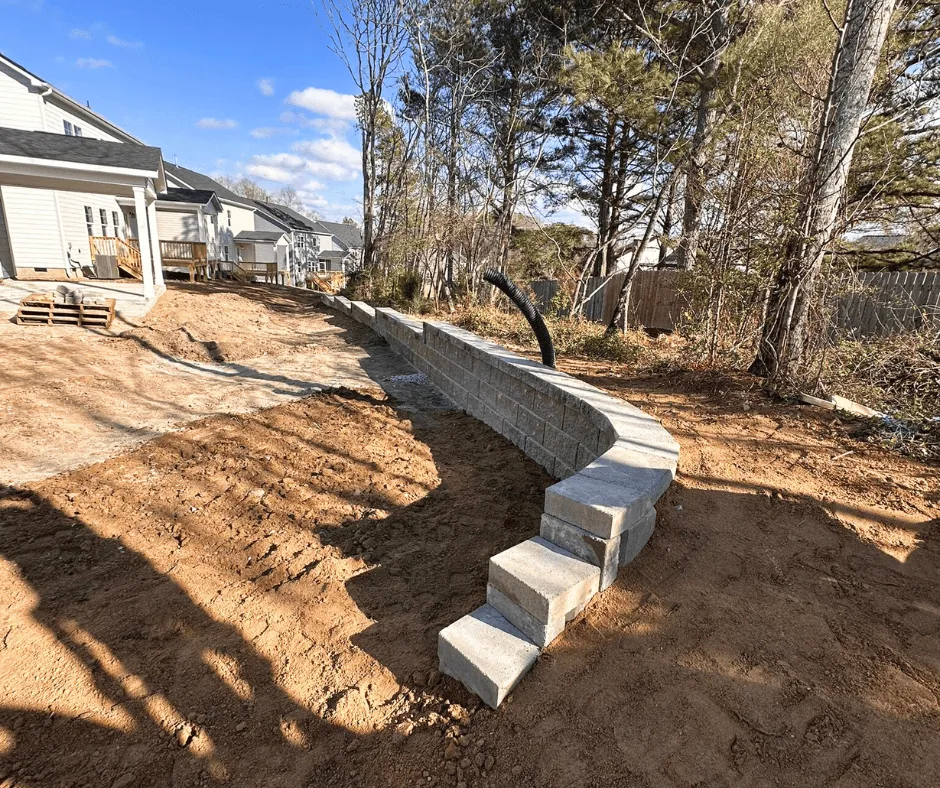 Curved retaining wall stabilizing a slope behind a North Carolina home