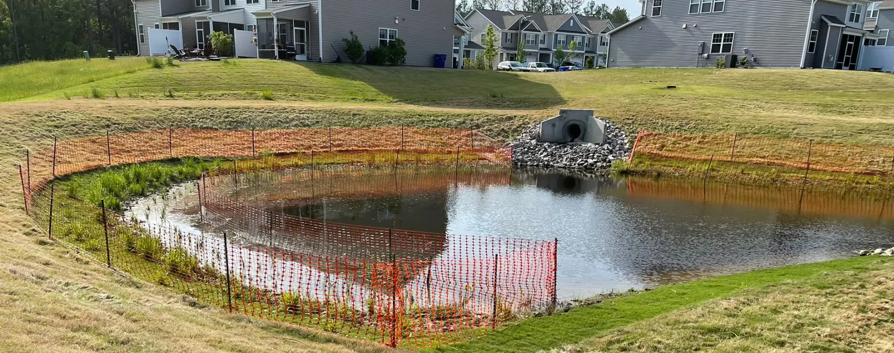 Pond conversion with silt fence around a retention pond in a North Carolina neighborhood